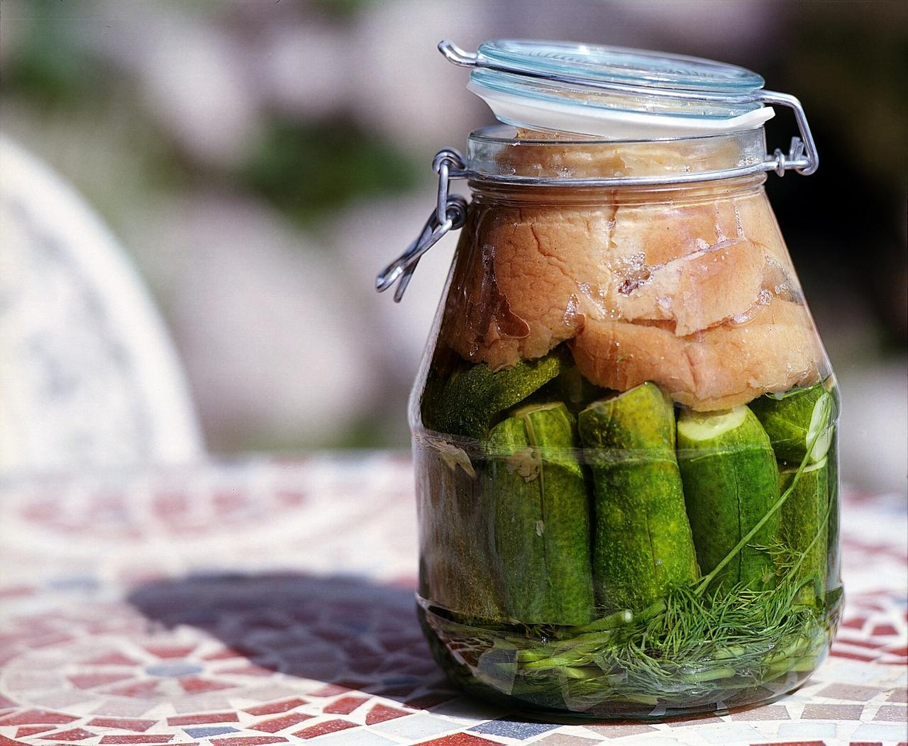 A glass jar of pickled cucumbers with dill