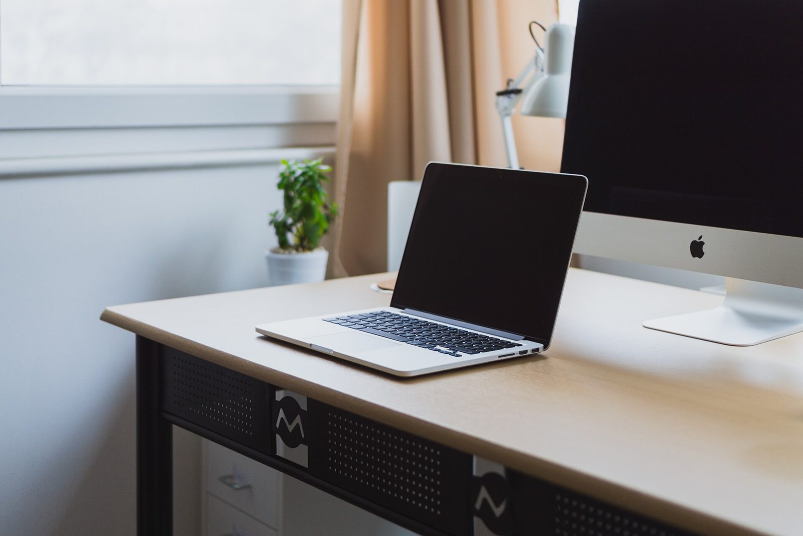 Laptop on a desk by a window